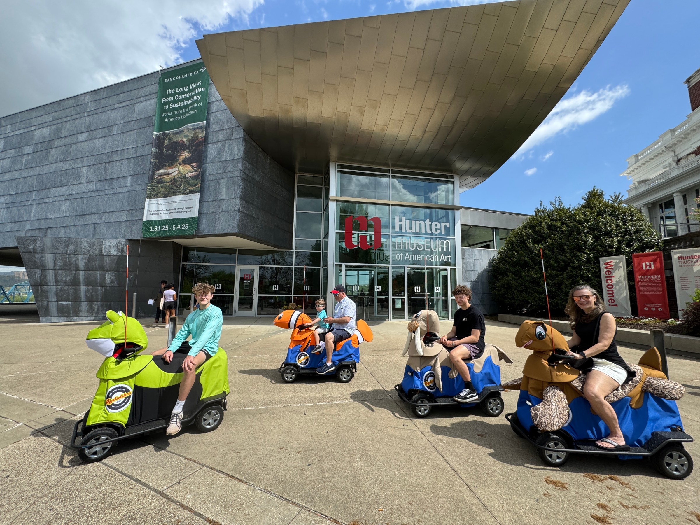 a group of people sitting on a motorcycle in front of a building