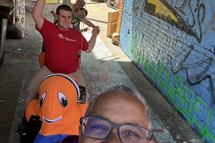 a man wearing sunglasses and standing in front of a building
