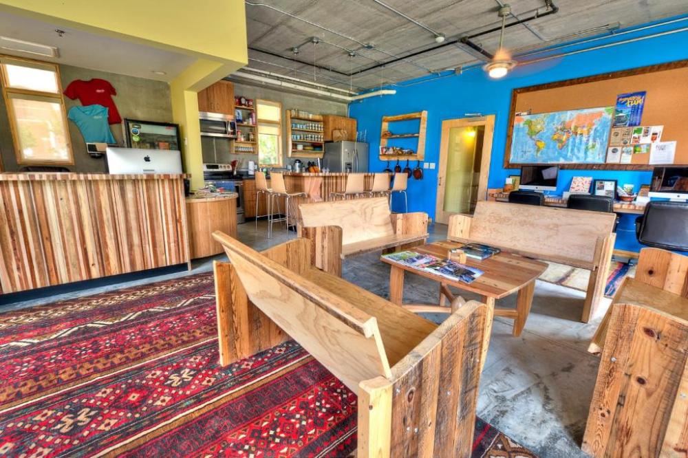 Colorful lounge with wooden furniture, a world map, and a patterned rug.